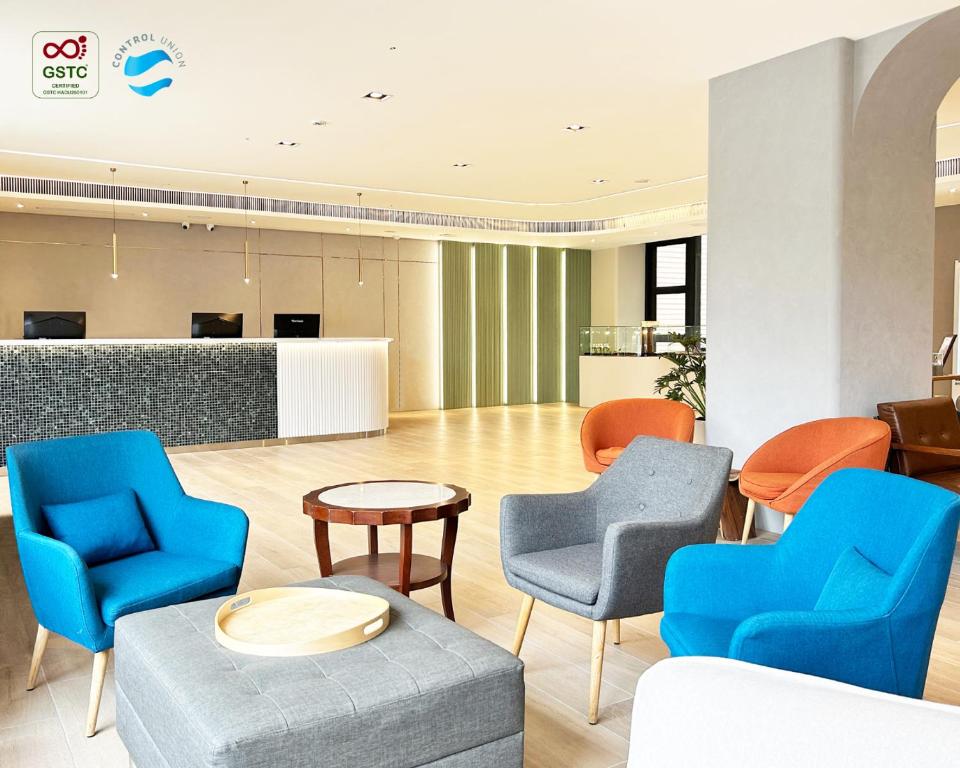 eine Lobby mit blauen und orangen Stühlen und einem Tisch in der Unterkunft Azure Hotel in Hualien