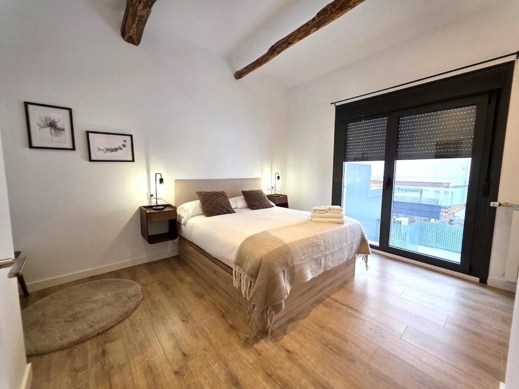 a bedroom with a bed and a large window at El Rincón de Santa Eufemia in Ourense