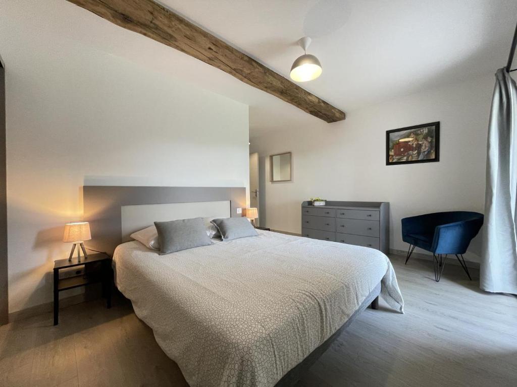 a bedroom with a bed and a blue chair at Elizetxea in Larceveau-Arros-Cibits