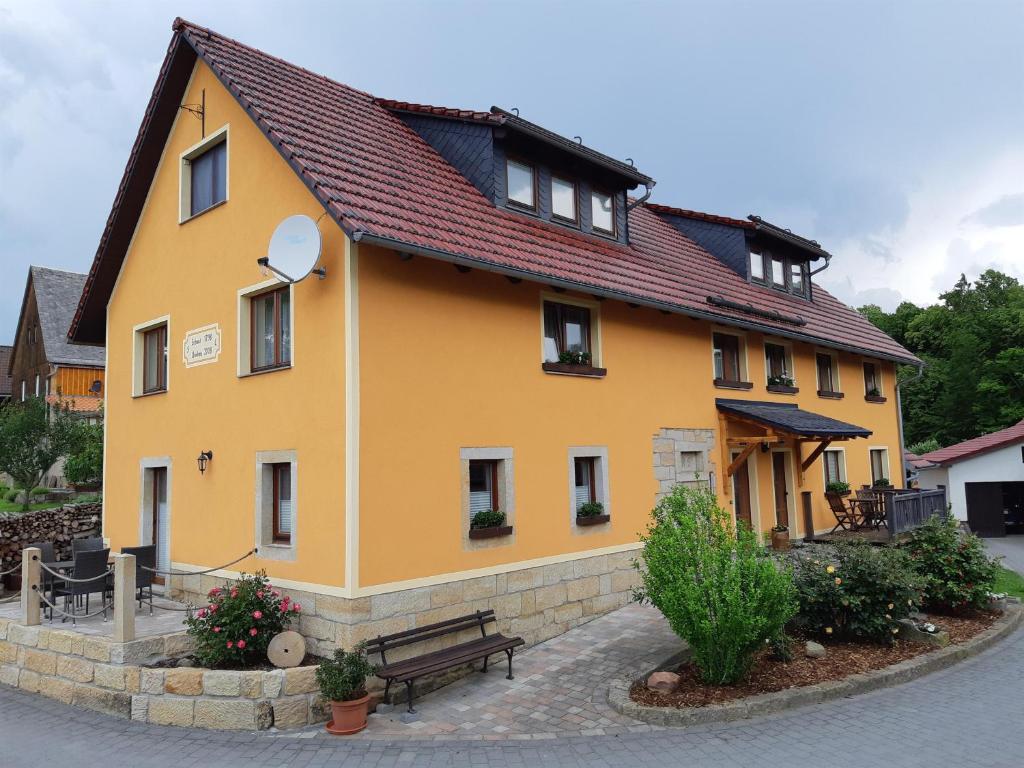 a yellow house with a bench in front of it at Ferienhof Leuner Sandro in Bad Schandau