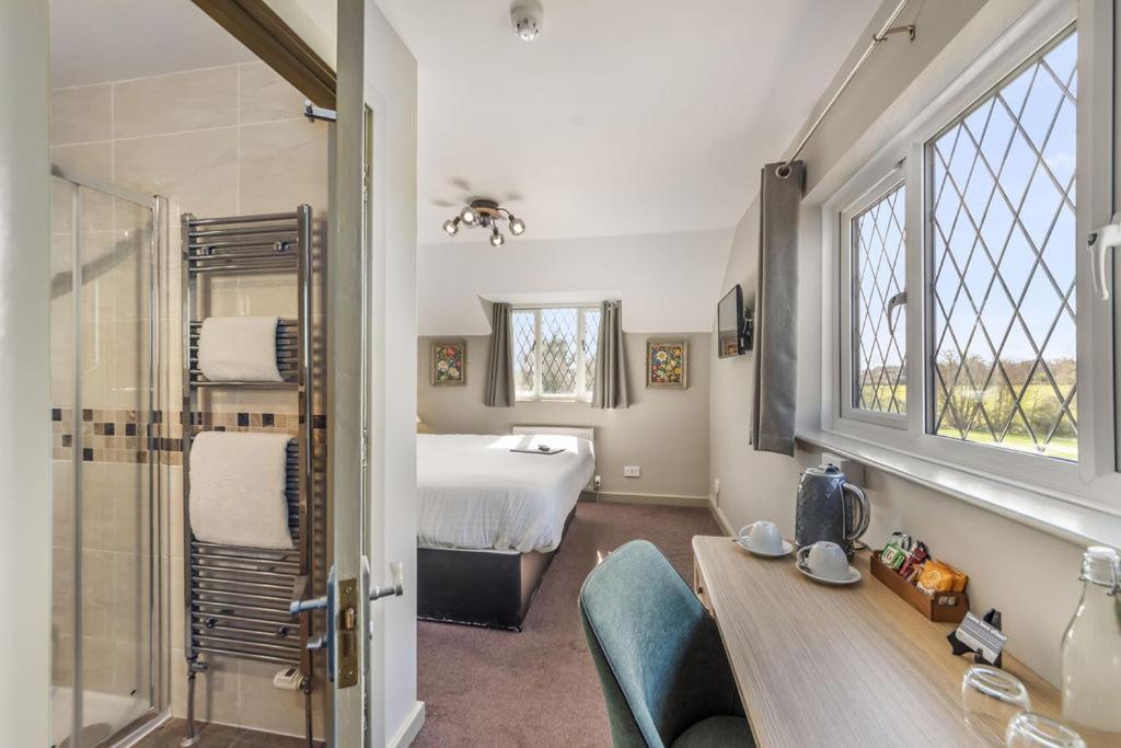 a bathroom with a bedroom with a bed and a shower at The Throckmorton in Alcester
