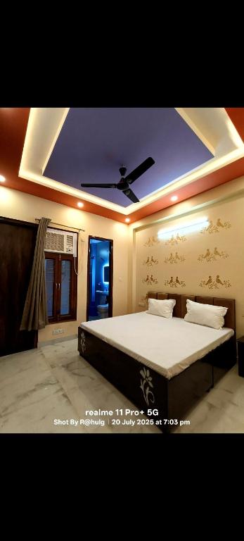 a bedroom with a large bed with a ceiling at Fng Guest House in Noida