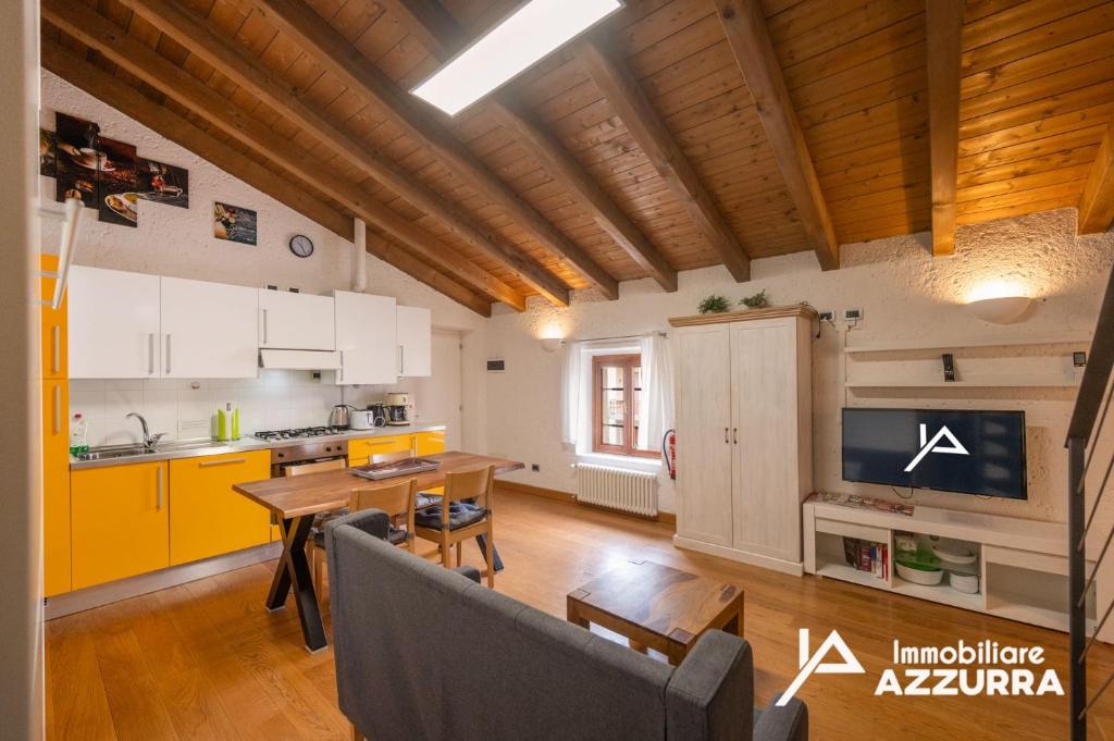 a kitchen with a table and a dining room at Aly d'Angelo alla Torre - Immobiliare Azzurra in Bardolino