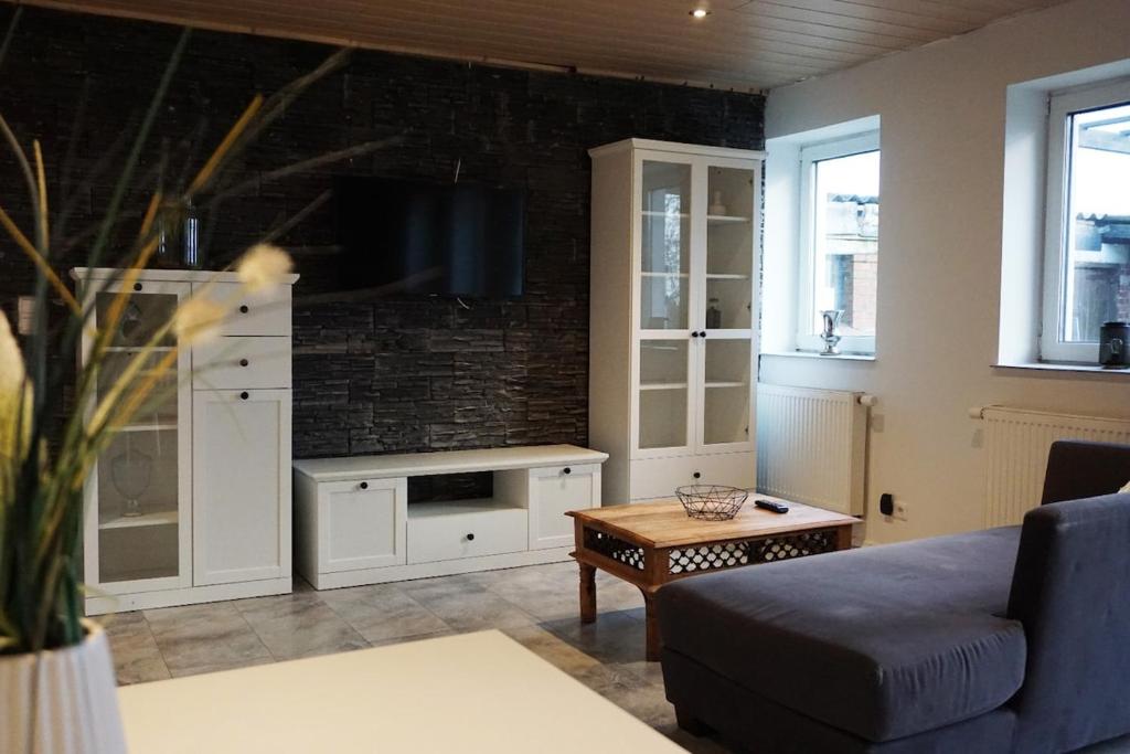 a living room with a couch and a tv at Leuchtturmnest in Krummhörn