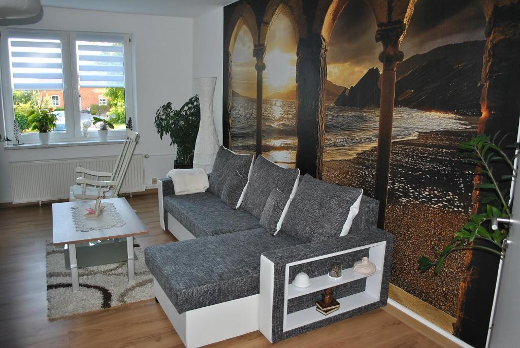 a living room with a couch and a painting at Ferienwohnung Thiedmann in Hagebök