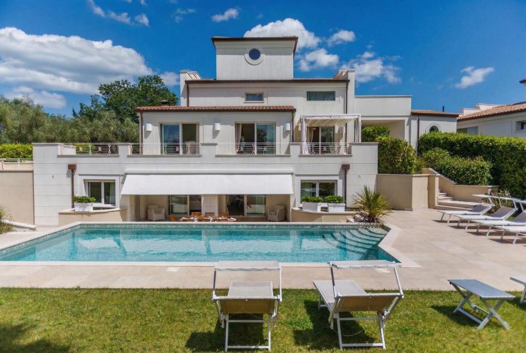 a villa with a swimming pool in front of a house at VILLA MANDARA 8&2, Emma Villas in Misano Adriatico