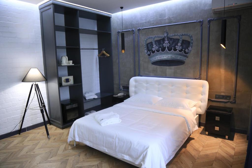 a bedroom with a white bed with a crown above it at Bugu Hotel Bishkek in Bishkek