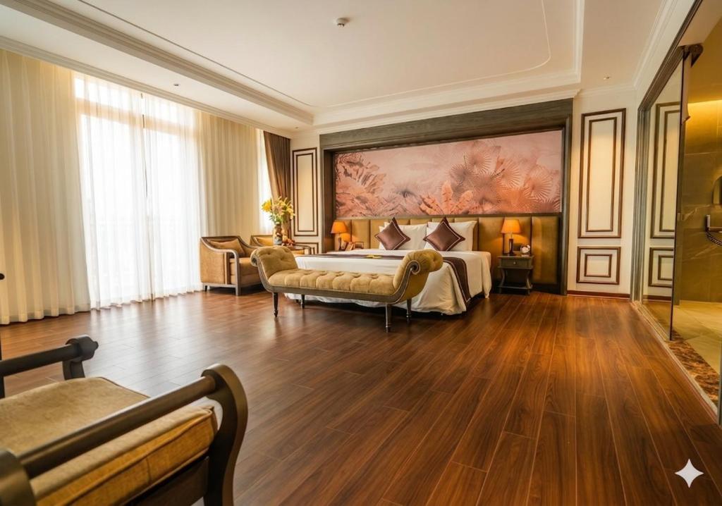 a bedroom with a bed and a large painting on the wall at Bảo Long Lào Cai Hotel in Lao Cai
