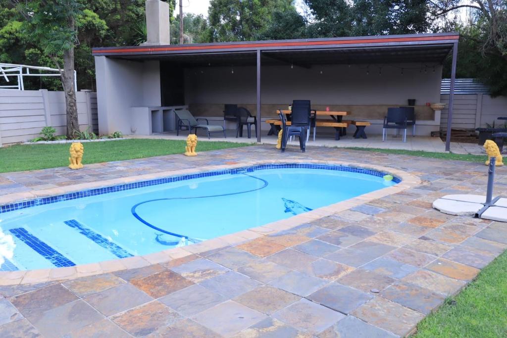 a swimming pool in a yard with a patio at Guesthouse Gabby in Klerksdorp