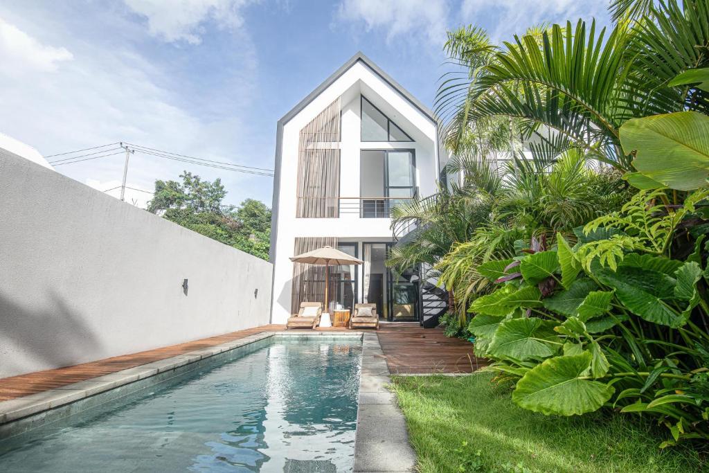 a house with a swimming pool in front of a house at Modern 2BR Villa Samudra Ocean View Nusa Dua in Ungasan
