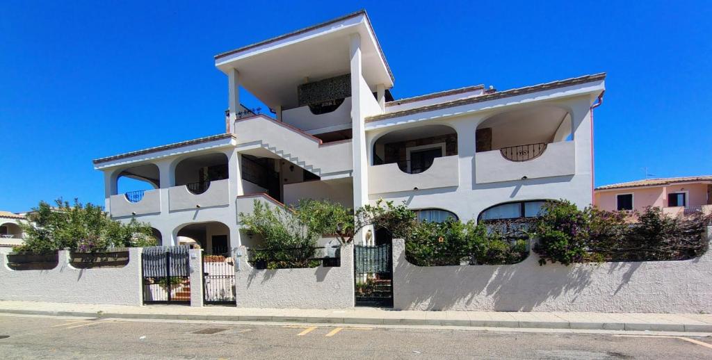 a white building with potted plants on it at Appartamenti Il Glicine Villasimius in Villasimius