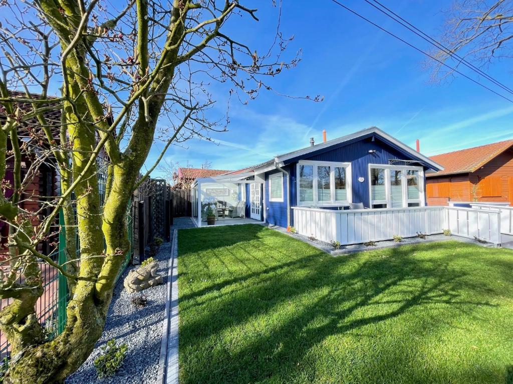 a home with a blue house with a yard at Leonies Emsblick in Walchum