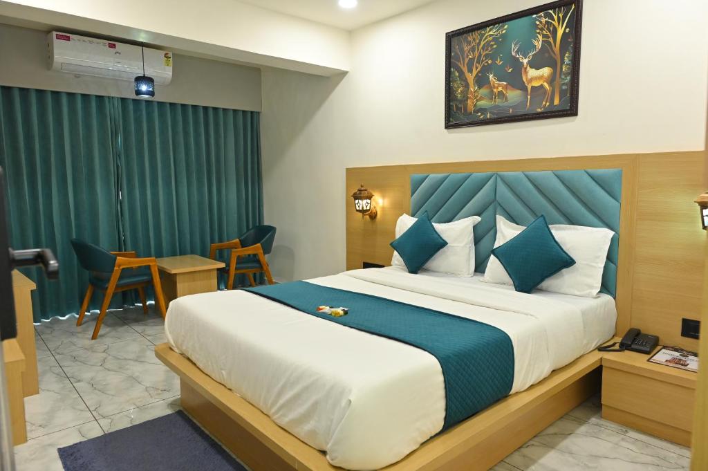 a hotel room with a bed and a table and chairs at Hotel Revanta Inn in Ahmedabad