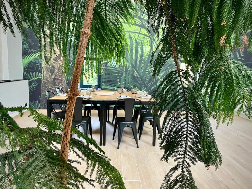 a dining room with a table and some palm trees at Big Jungle in Grane
