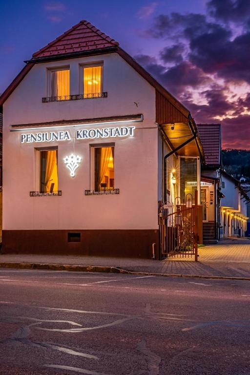 a building with a sign on the side of a street at Pensiunea Kronstadt in Braşov
