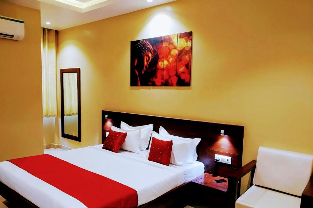 a bedroom with a large bed with red pillows at Sangam Hotel in Kiul