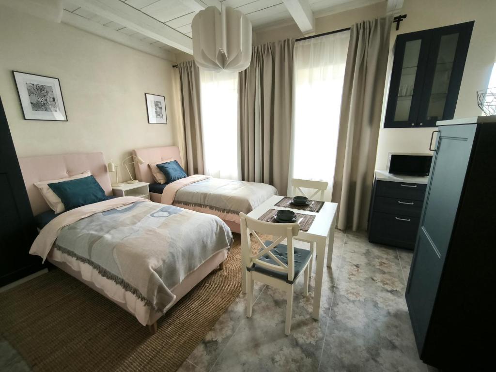 a hotel room with two beds and a desk at Studio Apartment Self Check-in in Mažeikiai