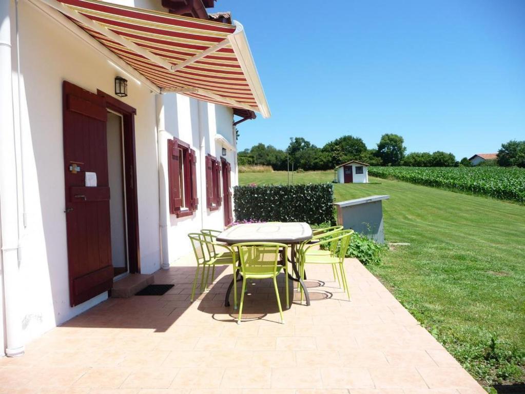 eine Terrasse mit Tisch und Stühlen an der Seite eines Hauses in der Unterkunft Gorpulania in Arbonne