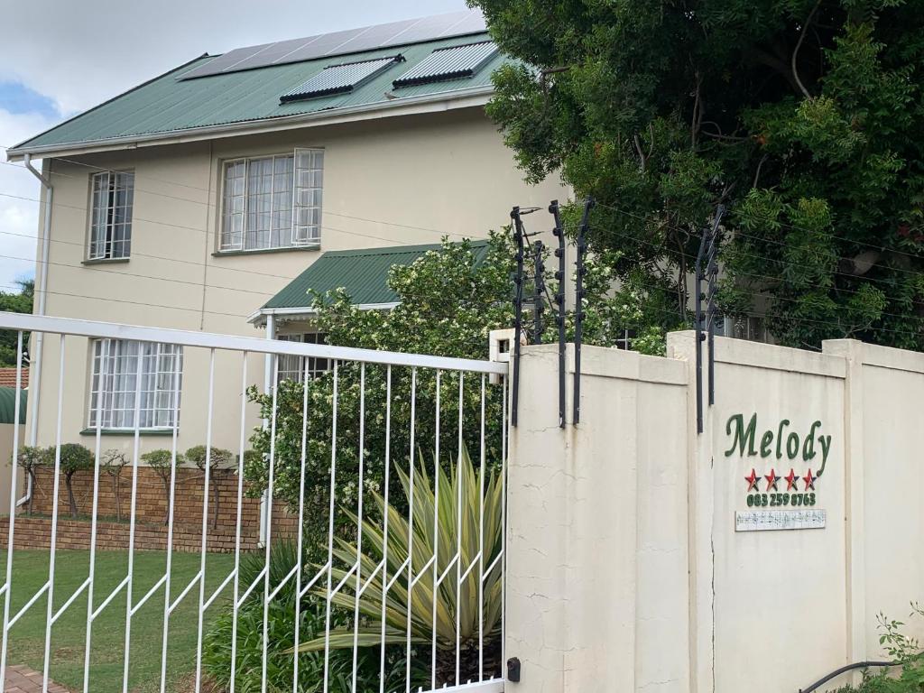 a white fence in front of a house at Melody Guest House in Centurion