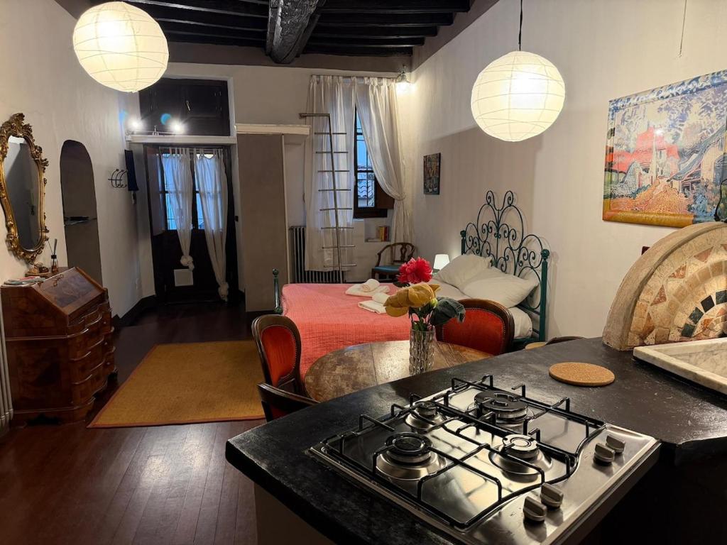 a kitchen with a stove and a living room with a bed at Assisi 2 by E-Roi Rent - Museo Egizio in Turin