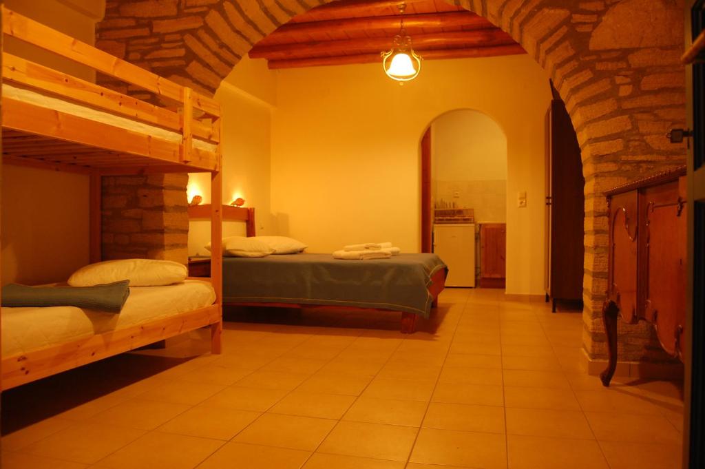 a bedroom with two beds and a kitchen in the background at Maistrali in Iraklia