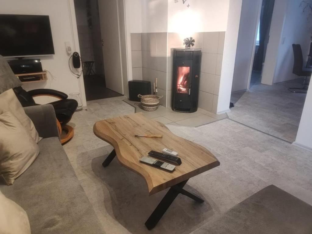 a living room with a coffee table and a fireplace at NEU! Ferienwohnung am Ahlberg in Toppenstedt