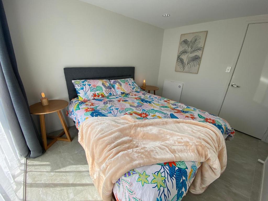 a bedroom with a bed and a table with candles at 2 Bedroom Unit in Howick in Auckland