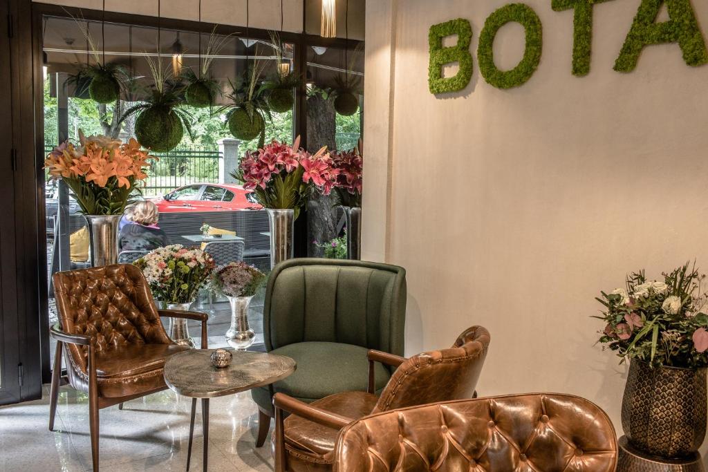 a room with chairs and a table and a sign that says sofa at Hotel Botanica in Belgrade