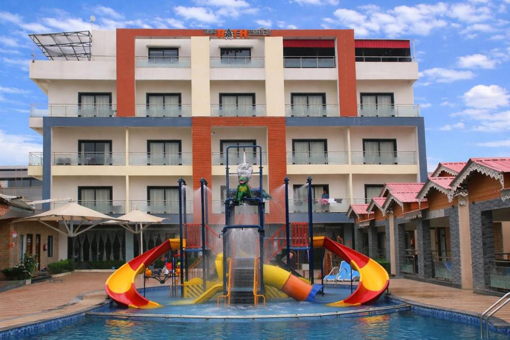 a pool with a water slide in front of a building at Rath Inns Beach Resort Mandarmani in Mandarmoni