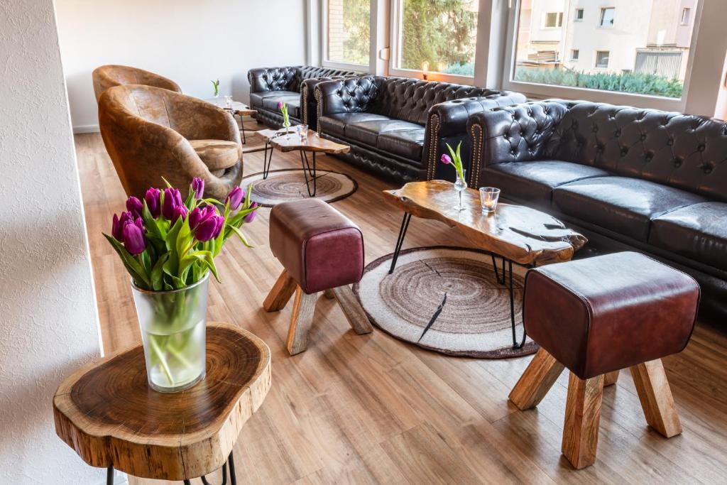 a living room with couches and tables and flowers at Forest Monteurzimmer & Fewo für Firmen & Gruppen in Bad Bevensen