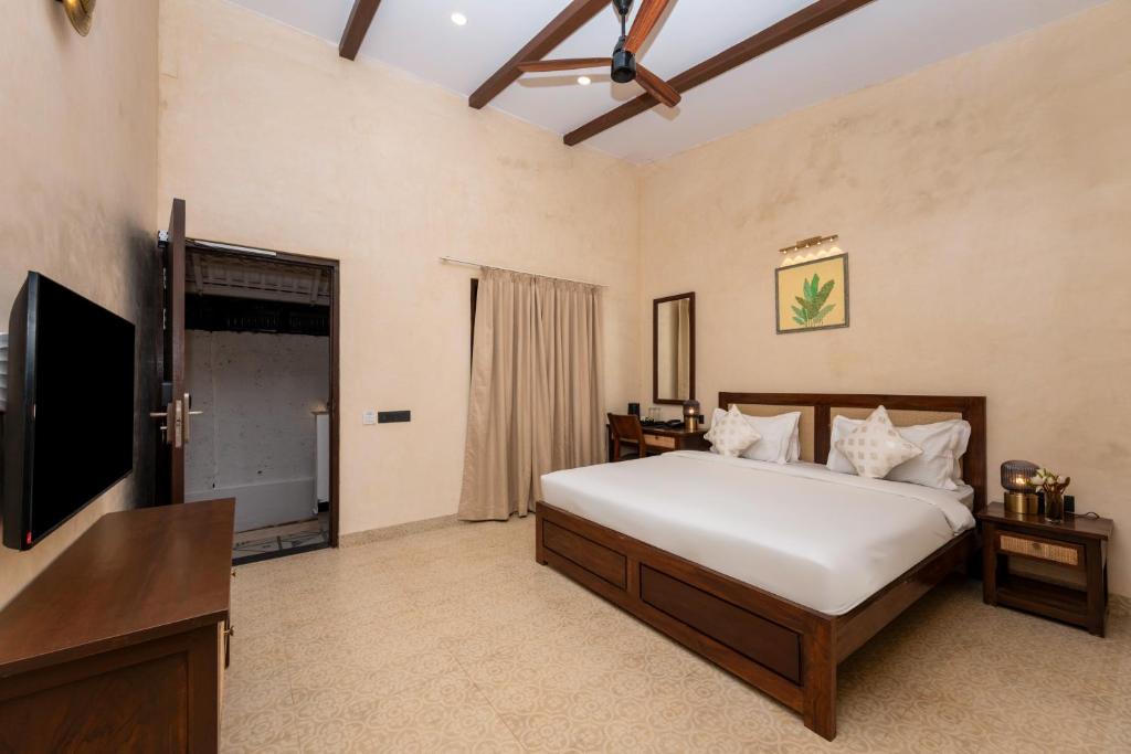 a bedroom with a bed and a flat screen tv at Yellowstone Resort Arambol in Arambol