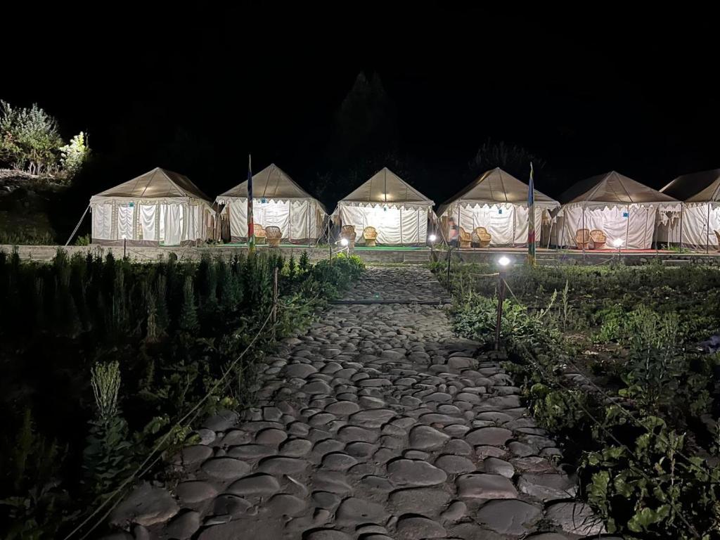 a row of tents at night with a stone path at Jispa Journey Camp Lahoul & Spiti in Manāli