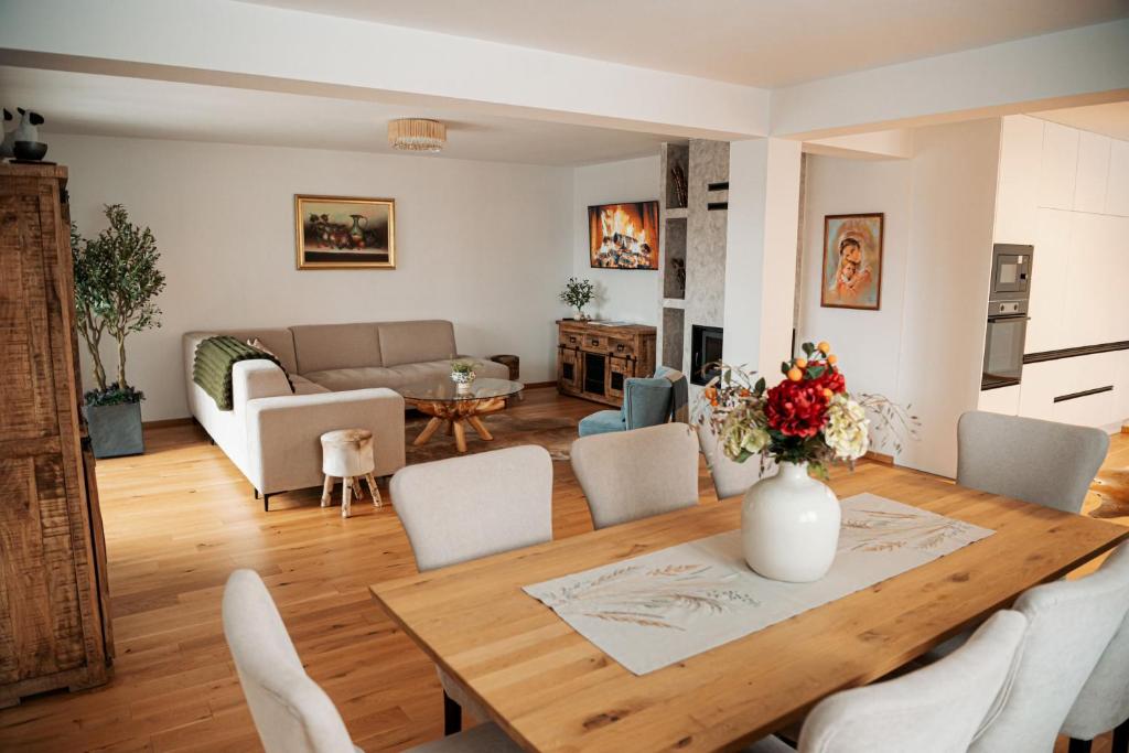 a dining room and living room with a table and chairs at Penzión Slnečná in Lendak