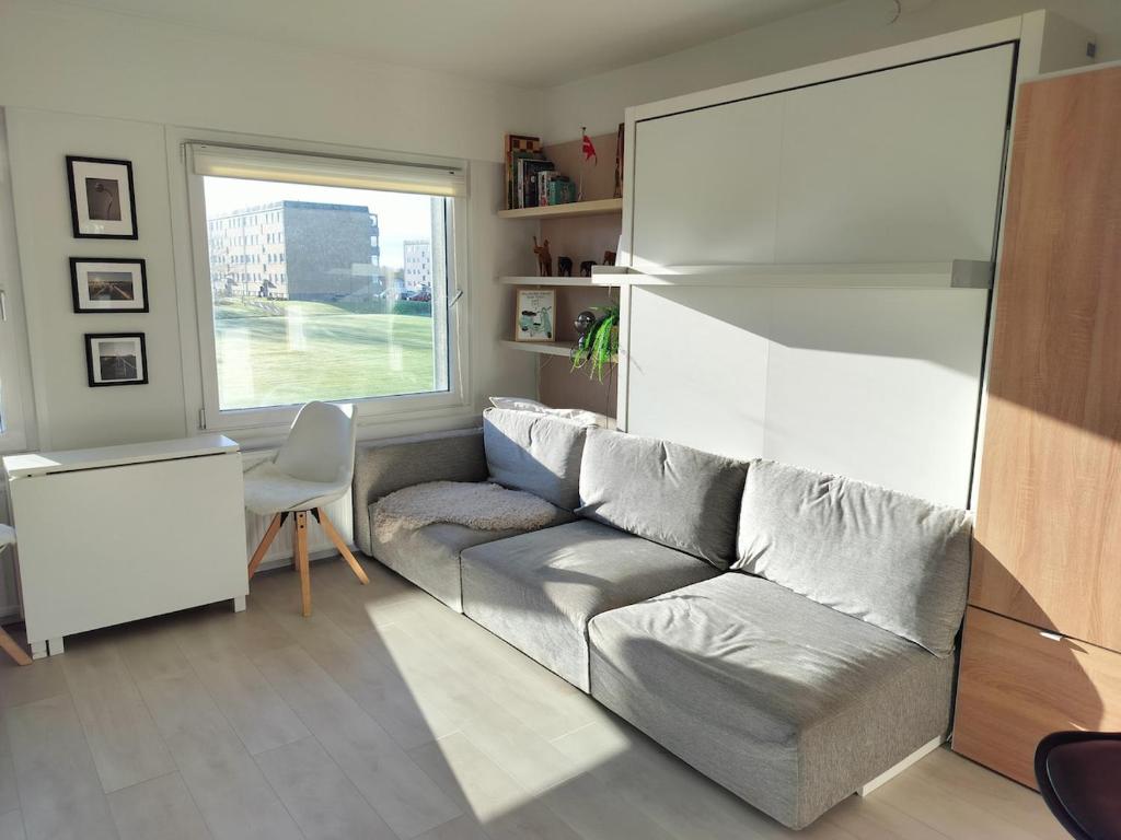a living room with a couch and a window at Cozy Apartment in Nørresundby