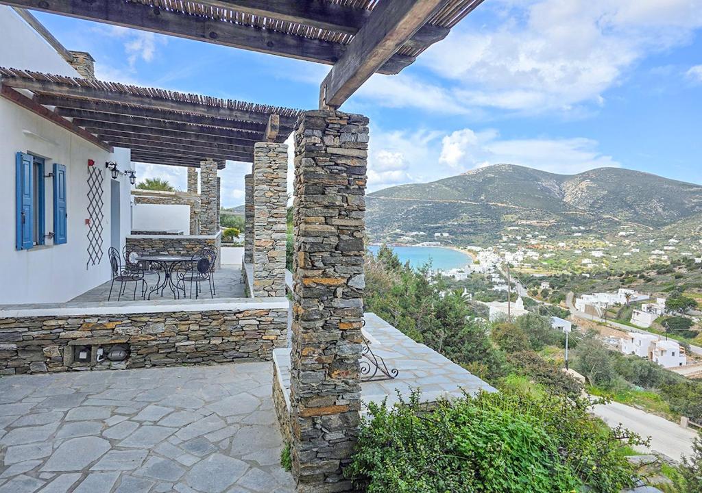 a patio with a table and chairs on top of a house at Panostria Apartments Sifnos in Sifnos