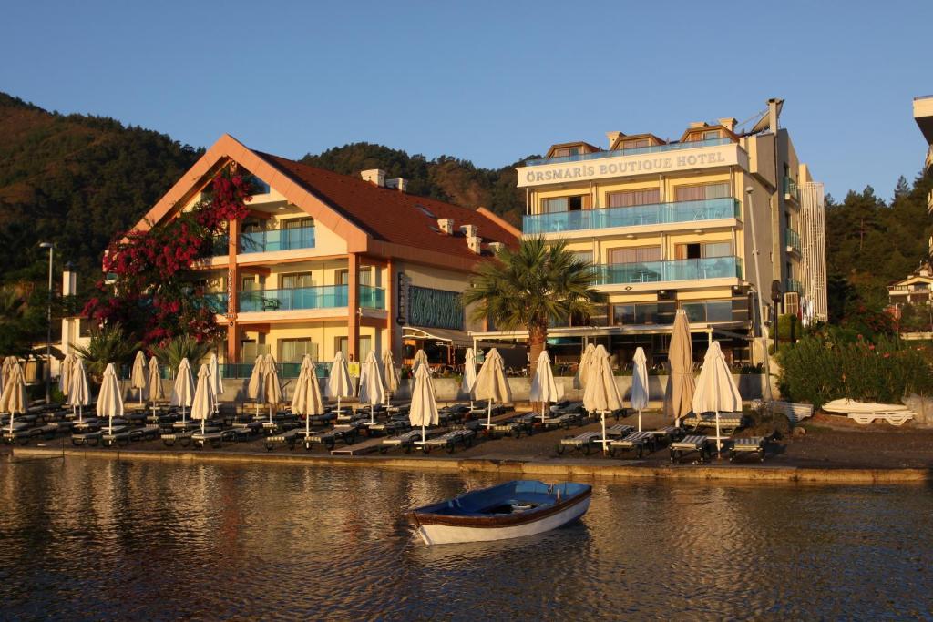 a boat in the water in front of a hotel at Örsmaris Boutique Hotel in Marmaris