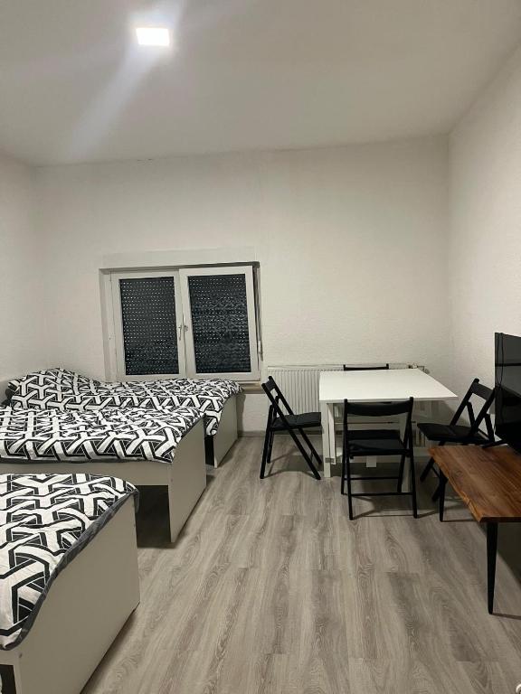 a room with two beds and a table and chairs at Monteurswohnung Hamm in Hamm
