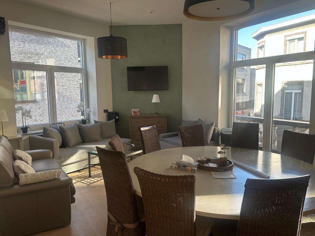 a living room with a table and a couch at Villa Le Roy in Blankenberge