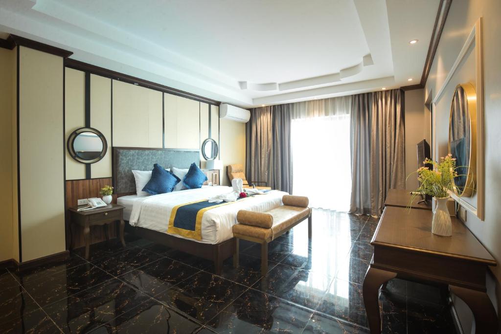 a bedroom with a bed and a desk and a piano at Eden De Vangvieng in Vang Vieng