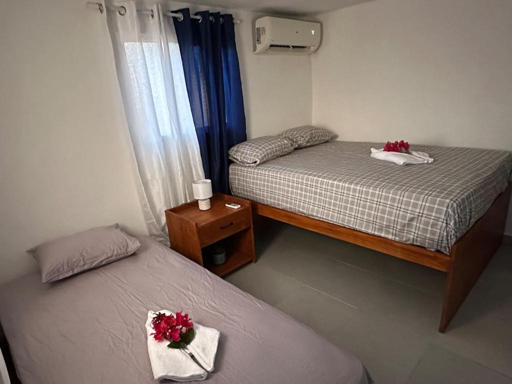 two beds in a small room with flowers on them at Brise Dorée de Punta Rucia in Punta Rucia