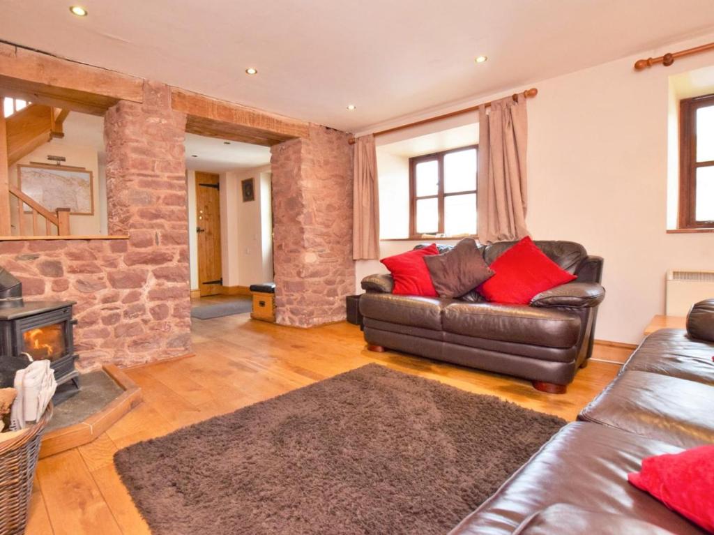a living room with a leather couch and a fireplace at 2 Bed in Minehead oc-41218 in Timberscombe