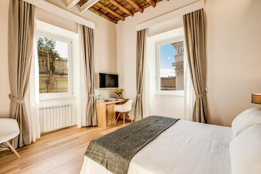 a bedroom with a bed and two windows at Dopodomani Suite in Rome