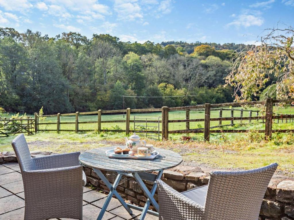 a table and chairs on a patio with a fence at 1 Bed in Tiverton oc-94766 in Bampton