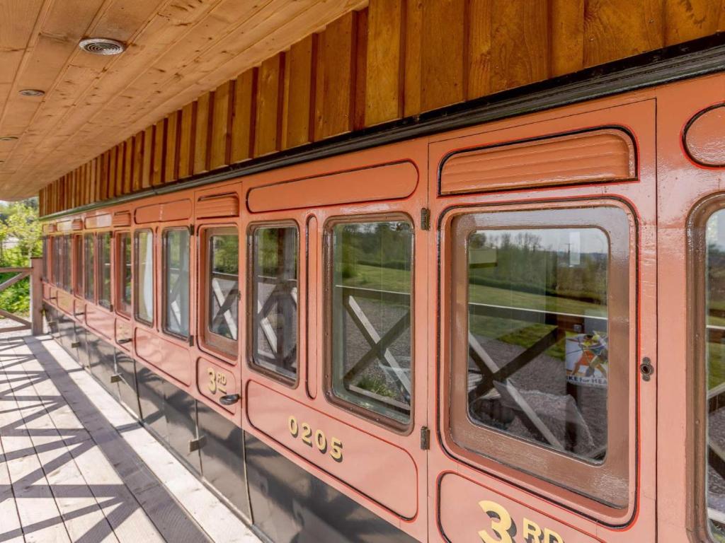 a red train is parked at a train station at 1 Bed in Exeter oc-75423 in Longdown