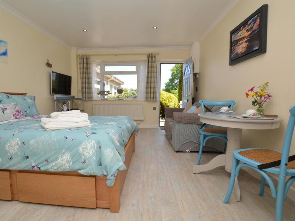 a bedroom with a bed and a table and chairs at 1 Bed in Bridport oc-41890 in Charmouth