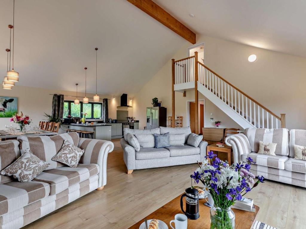 a living room with two couches and a staircase at 5 Bed in Dulverton oc-87003 in Morebath