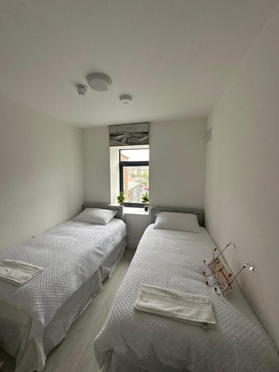 two beds in a room with a window at Milk Market Inn in Limerick