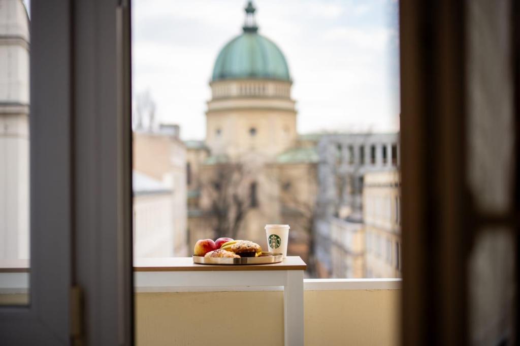 a plate of food and a cup of coffee on a window at Super Central Modern Flat with Balcony & View! #55''Smart TV #Fast Wi-Fi #Metro in Warsaw