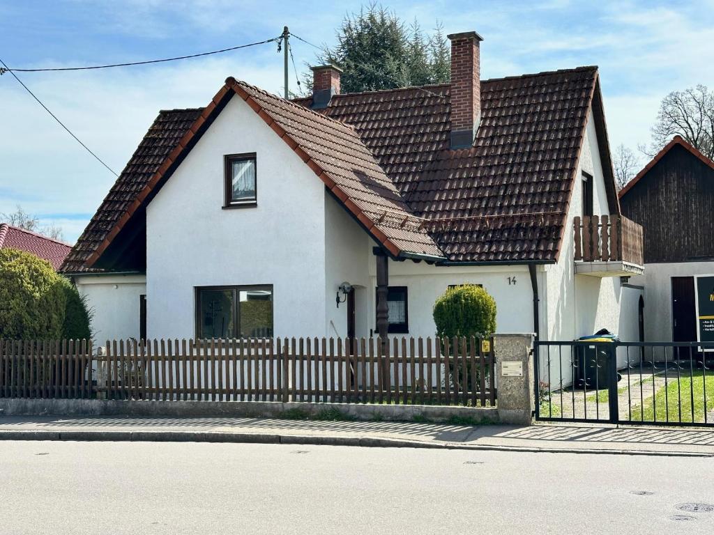 a white house with a wooden fence at Haus der Monteure in Stadtbergen