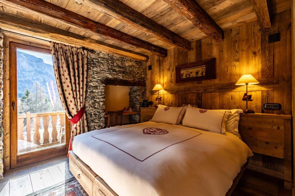 a bedroom with a bed in a room with a window at La Luge D'Antan Maison d'Hôtes & SPA in Brusson
